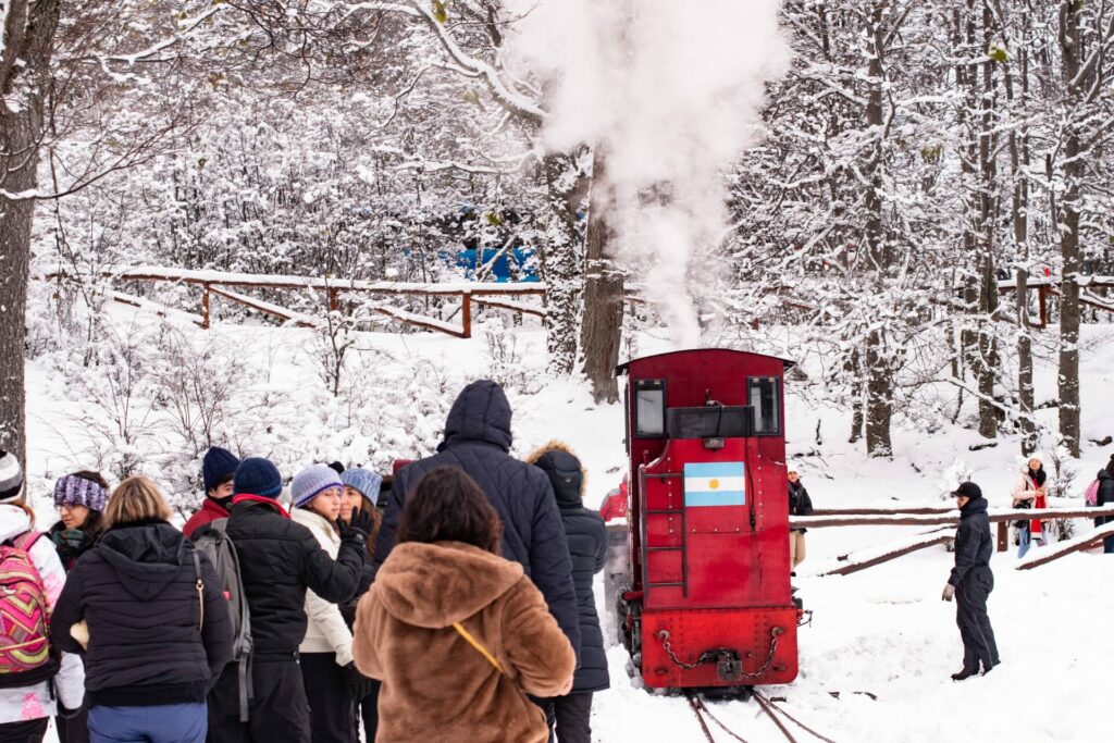 Uno de los trenes del fin del mundo llegando a una estaciòn en temporada invernal