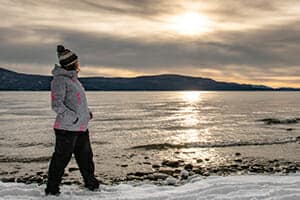 Turista apreciando las hermosas vistas que ofrece el Lago Fagnano durante el invierno