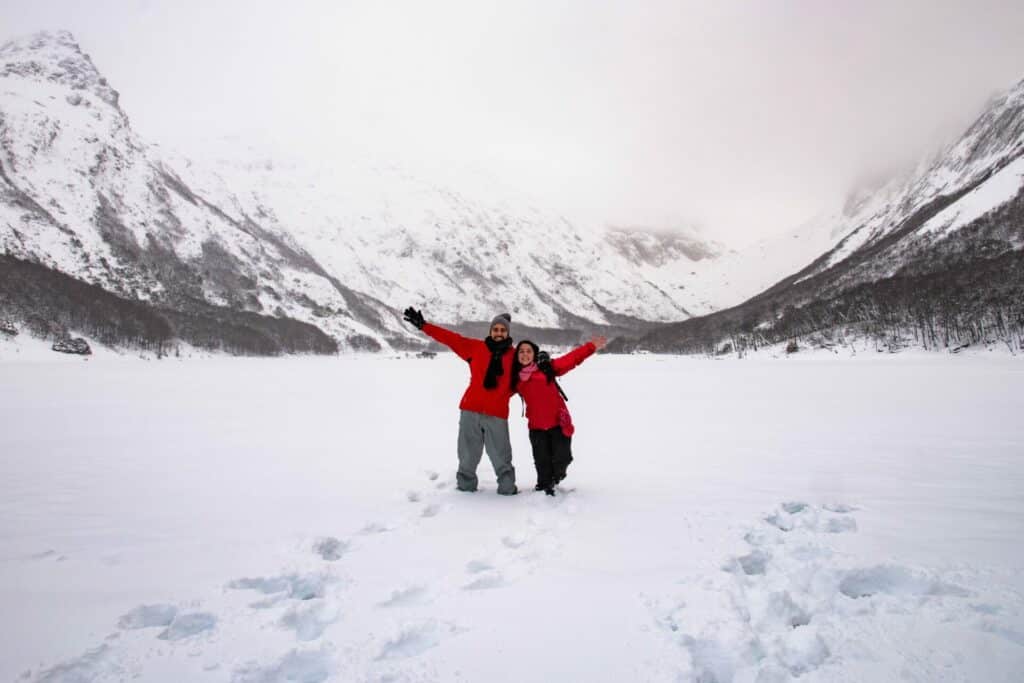 Excursionistas disfrutando de la Laguna Esmeralda cubierta de nieve