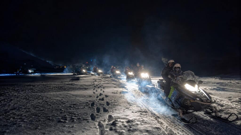 Excursionistas manejando motos de nieve en nuestra excursiòn invernal "Noches Blancas"
