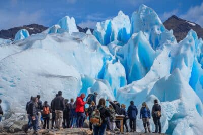 Turistas teniendo una vista muy de cerca del glaciar durante excursión