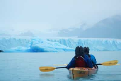 Excursionistas remando en las calmadas aguas del lago en direcciòn al glaciar Perito Moreno