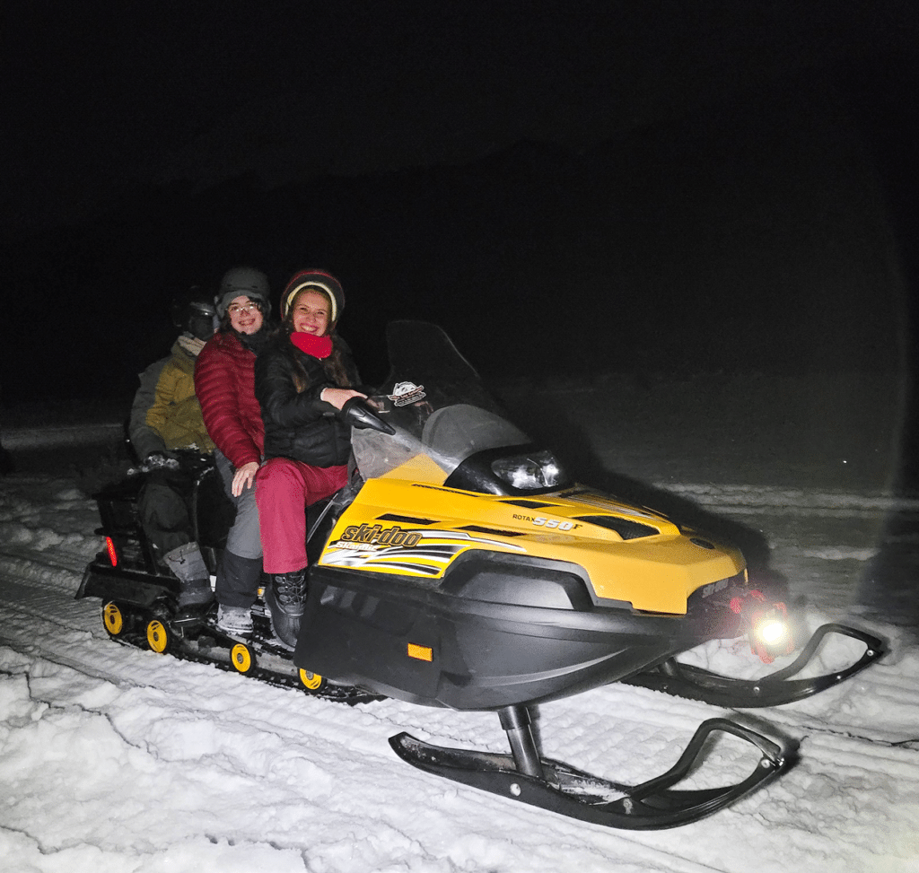 Excursionistas manejando motos de nieve en la excursión Noches Blancas