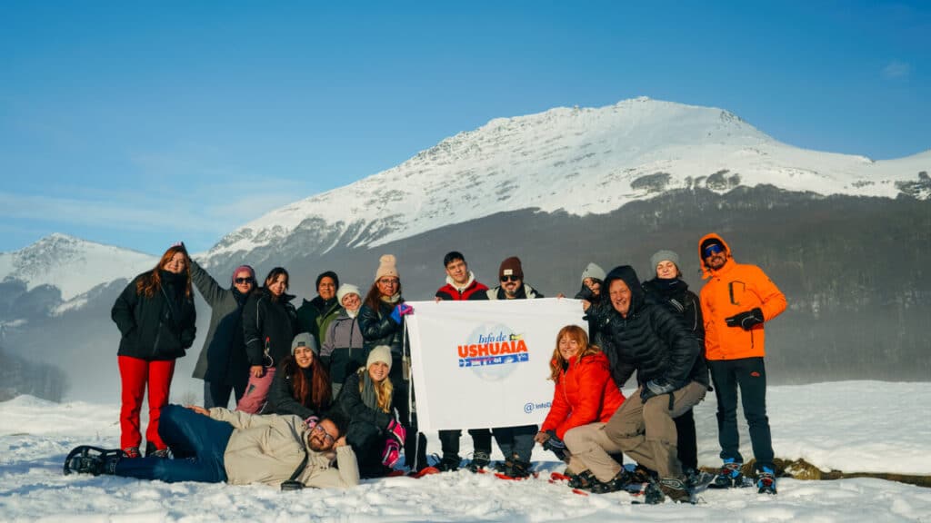 Grupo de personas en la nieve disfrutando una excursión con Info De Ushuaia