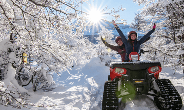excursionistas disfrutando la Experiencia Nieve en Ushuaia a bordo de los cuatriciclos con orugas