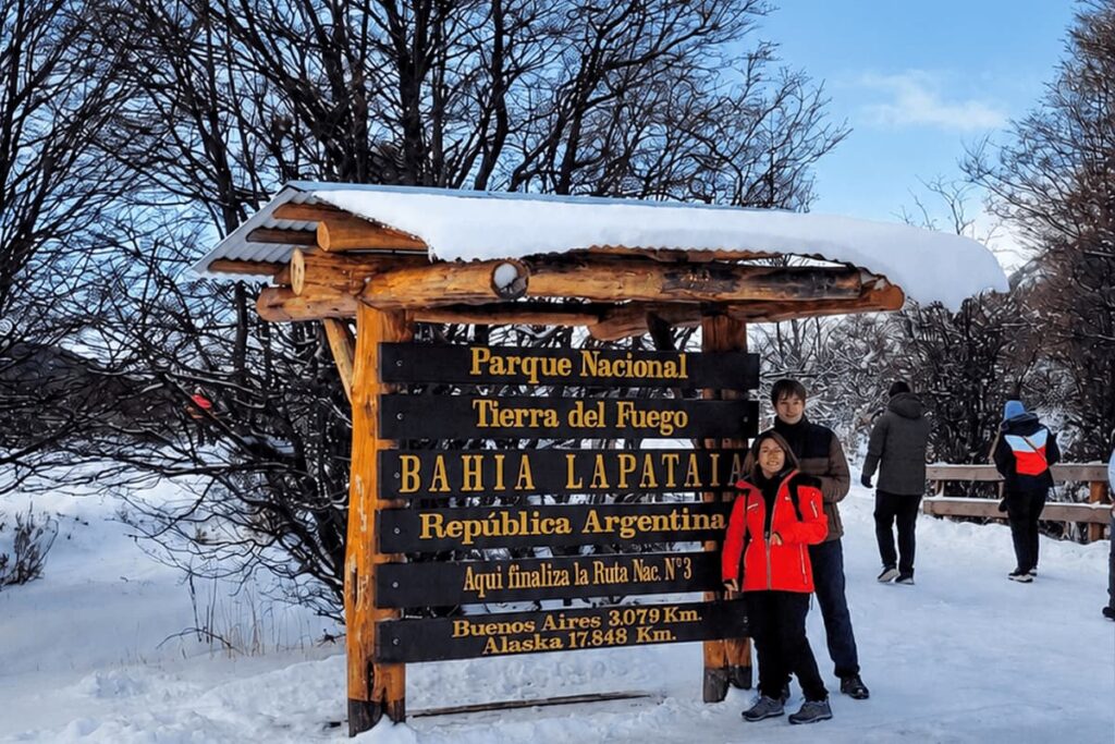 turistas en cartel de bahía lapataia parque nacional tierra del fuego parte de las excursiones invernales en ushuaia